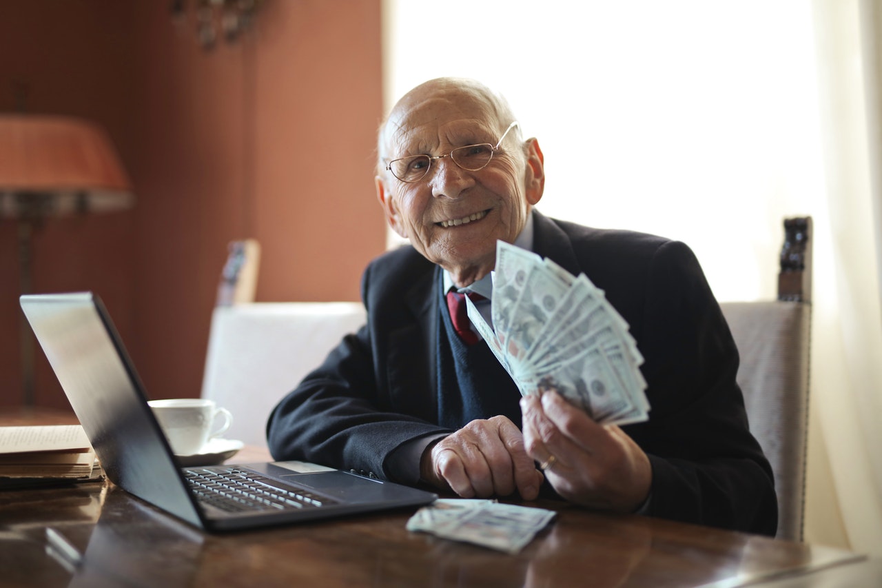 Oude man lachend met geld